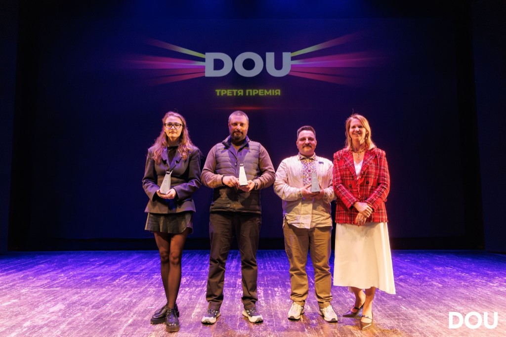 CyborgTests team on stage at the DOU Awards 2026 in Kyiv, holding trophies in front of the DOU screen.